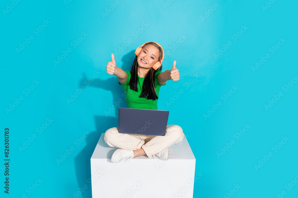 Full body portrait of pretty young girl sit cube show thumb up wear t-shirt isolated on turquoise color background