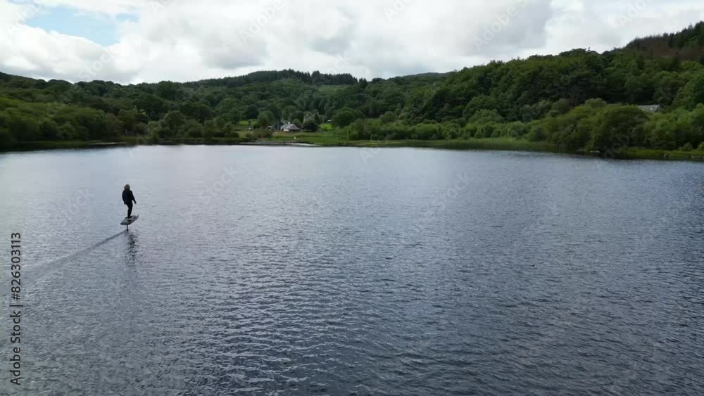 Drone of a male using electric surfboard on Llyn Georioned lake in Snowdonia National Park, Wales Drone of a male using electric surfboard on Llyn Georioned lake in Snowdonia National Park, Wales