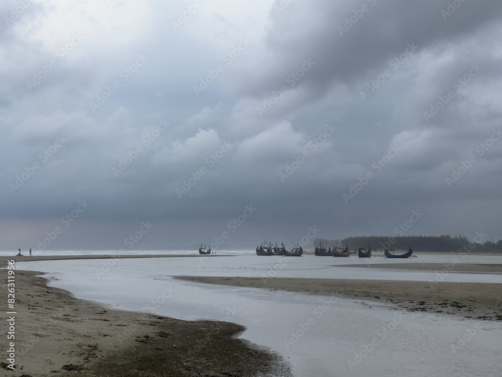 Traditional fishing vessels on deserted beach with storm in background, Cox's Bazaar, Bangladesh Traditional fishing vessels on deserted beach with storm in background, Cox's Bazaar, Bangladesh