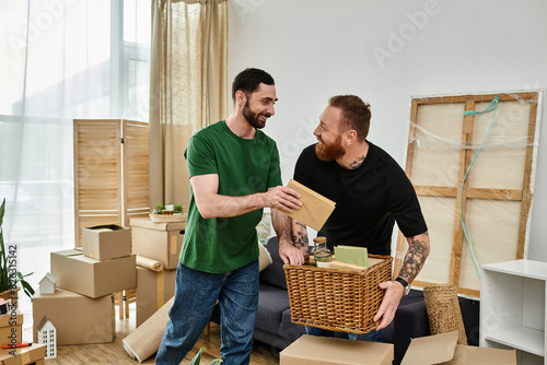 Two men, a gay couple in love, stand side by side in a room surrounded by boxes, starting a new life in their new home.