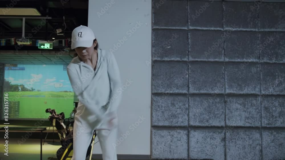 Lifestyle female in sportswear playing game golf and hitting out on screen simulator