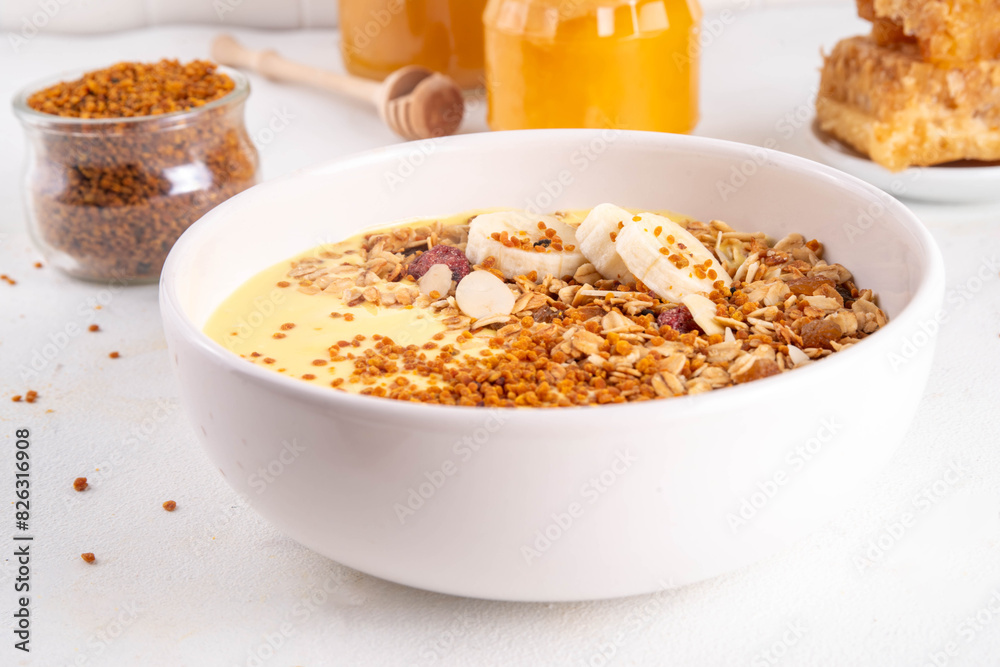 Healthy superfood fruit smoothie bowl with bee pollen, golden creamy shake or smoothie, with granola and banana. Clean eating, dieting vegetarian dish with bee pollen superfood organic powder Healthy superfood fruit smoothie bowl with bee pollen, golden creamy shake or smoothie, with granola and banana. Clean eating, dieting vegetarian dish with bee pollen superfood organic powder