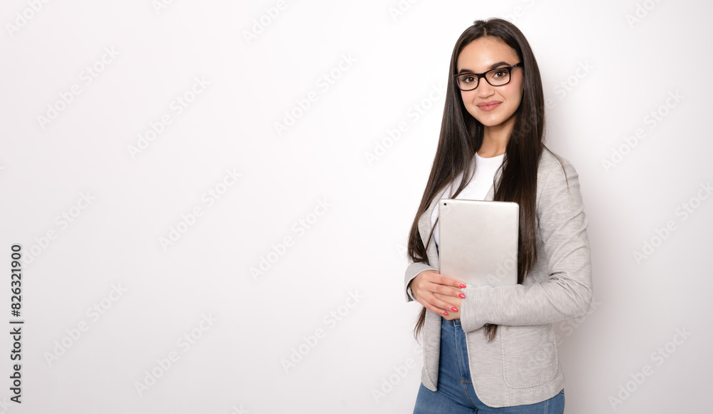 Portrait of happy young brunette business woman using tablet isolated against white background. Smiling pretty girl holding a digital tablet Portrait of happy young brunette business woman using tablet isolated against white background. Smiling pretty girl holding a digital tablet