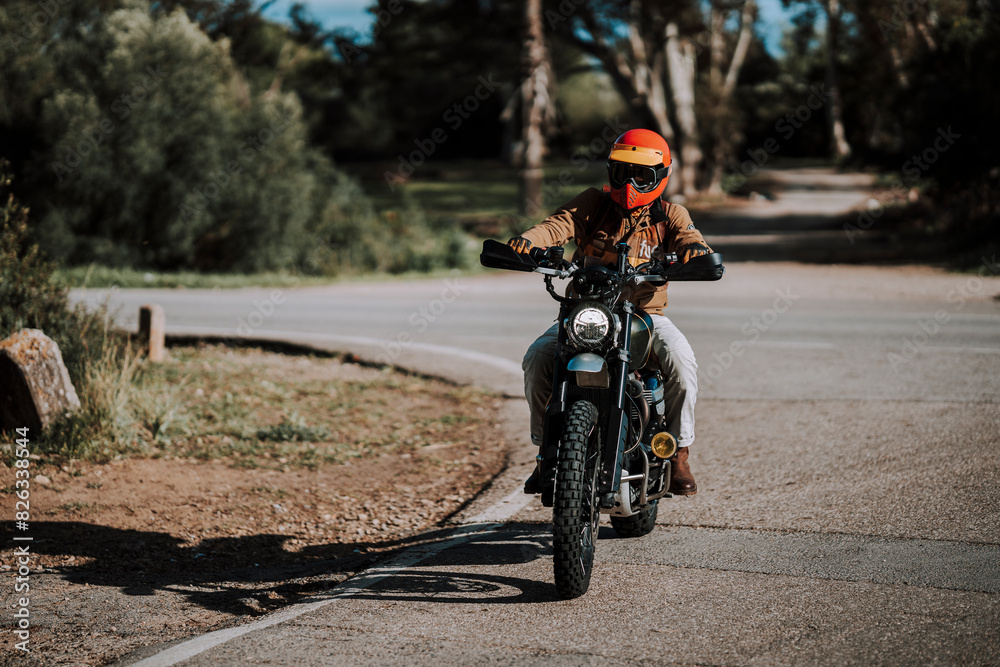 a person riding on a motorcycle down the road under a tree a person riding on a motorcycle down the road under a tree