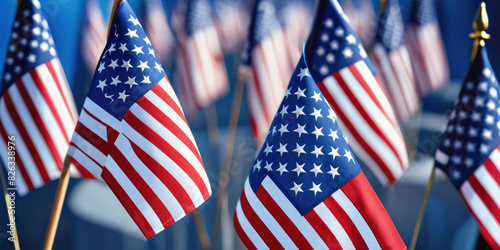 Memorial Day. Veterans Day. American Flags Displayed in a Row Against a Blue Sky. A row of American flags flying in the wind against a clear blue sky.
