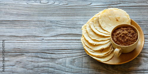 Tortillas made with nixtamalized white corn flour. Veracruz-style thick sauce made with dried chilies, pumpkin seeds, and unhulled sesame seeds. Traditional Mexican meal. Baner with copy space. photo