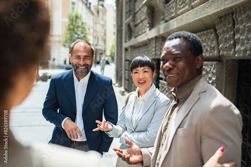 Group of businesspeople walking and talking in the city photo