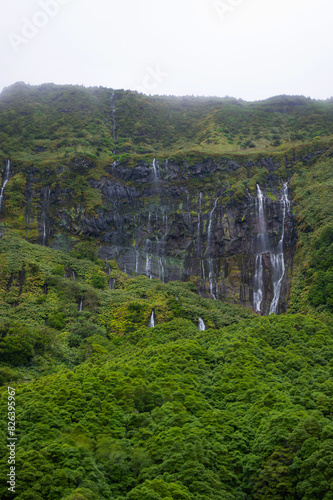Cascata da Ribeira do Ferreiro, Flores Island, Azores, Portugal. Long exposure waterfalls. Waterfall with tropical green vegetation and forests. Travel destination. Hiking on Azores Islands.