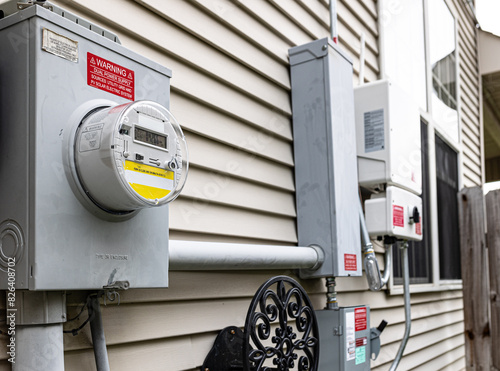 Utility electricity bill meter is connected to photovoltaic system inverter and a quick disconnect box, providing a dual power supply. Stickers indicating the solar panel source are placed as needed.