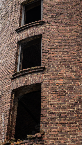 3 windows of an old, abandoned, brick tower