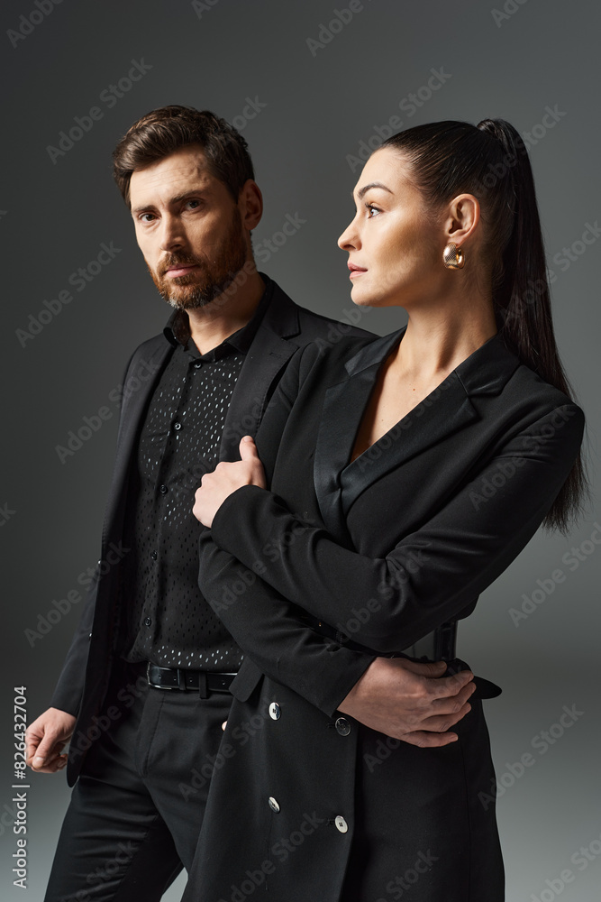 A man and woman dressed elegantly stand side by side, exuding love and grace. A man and woman dressed elegantly stand side by side, exuding love and grace.