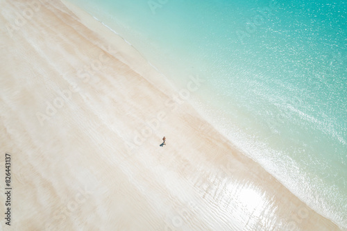 Aerial view of turquoise waters and sandy shore with person at Gantheaume Beach, Cable Beach, Western Australia, Australia. photo