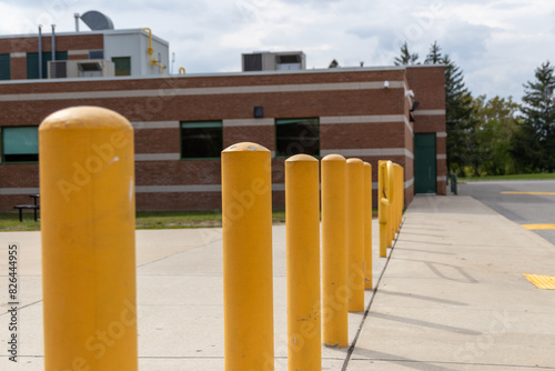 Yellow bollards lined up outside a brick building - industrial elements visible - under a partly cloudy sky. Taken in Toronto, Canada.