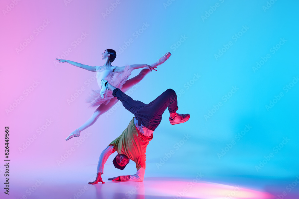 Classical and Contemporary Dance Duo. Duet of ballerina and street dancer, man and woman dancing on gradient background in neon light. Concept of classical and modern dance, performance
