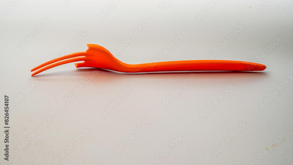 close up view of a broken orange fork isolated on white with empty space background. close up view of a broken orange fork isolated on white with empty space background.