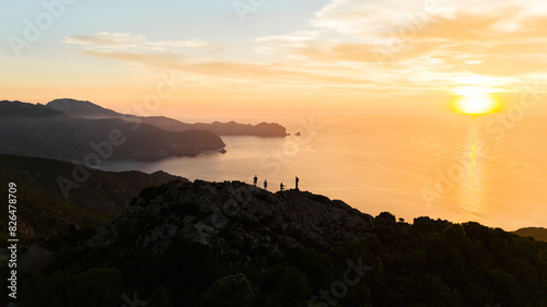 Aerial drone view of people standing on top of Mediterranean coast line during sunset, island of Corsica, France. photo