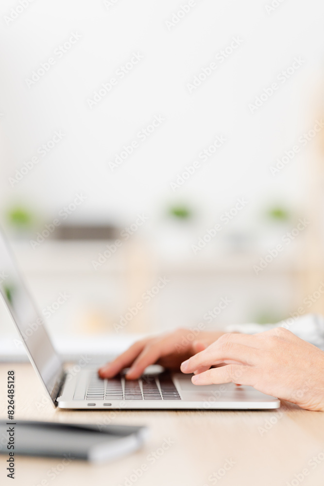 Close-up vertical photo of a Young man working at home with laptop Close-up vertical photo of a Young man working at home with laptop