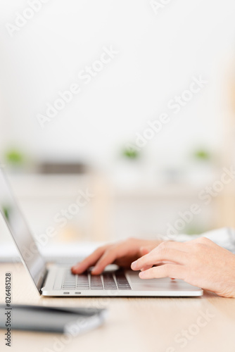 Close-up vertical photo of a Young man working at home with laptop