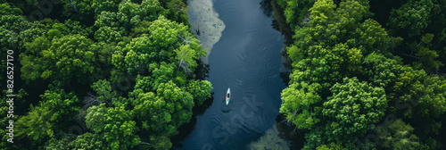 a drone view of a winding river through a lush forest with kayakers paddling