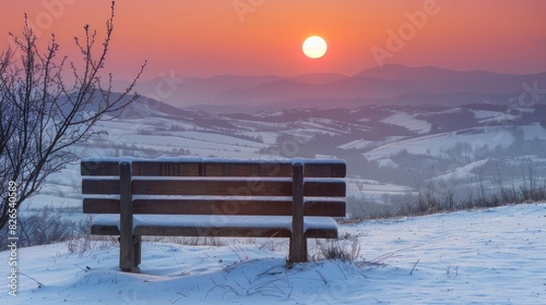 Wooden bench in the midst of a wide snowy landscape during the sunset with a red sun expansive view