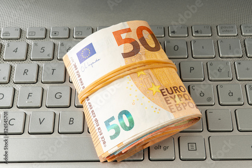 Euro banknotes on a laptop keyboard