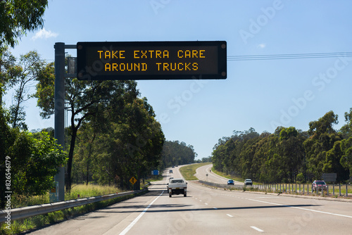 Overhead digital sign on highway reading take extra care around trucks photo