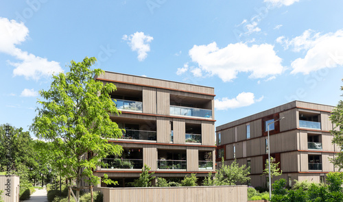 Residential area with ecological and sustainable green residential buildings, low-energy houses with wooden facade, timber construction and green courtyard