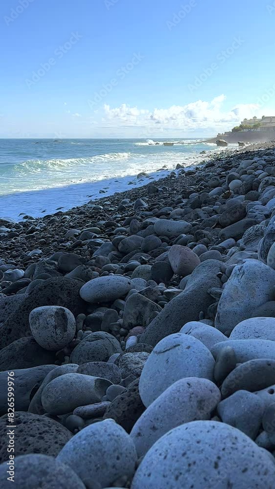 Pebble beach early in the morning. Waves on the Atlantic coast crashing against stones 