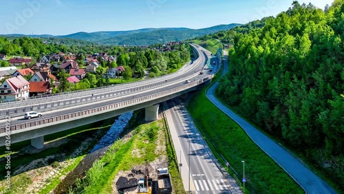 New elevated multilane highway and bend over old Zakopianka road in Lubien village in Poland, This motorway makes travel to Zakopane, Podhale region and Slovakia much faster. Aerial 4K video photo