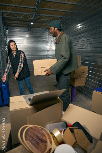 Team of coworkers containerizing wares in storage unit