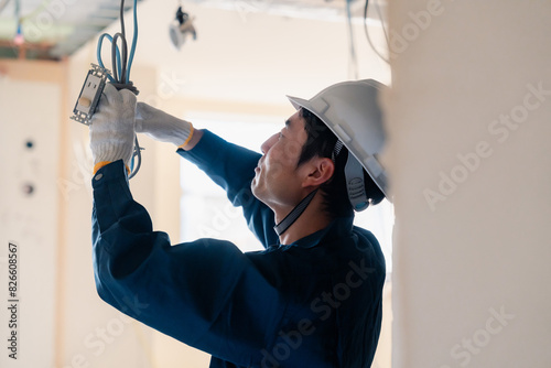 Foto 建築現場で配線工事をする電気工事士