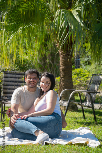 Família feliz sentada no jardim em dia ensolarada, Irmãos com suas esposa no jardim em meio a natureza, casal se divertindo em família photo