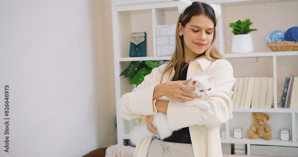 Cute pretty young beautiful woman is holding hugging embrace cute little fluffy a white cat in her arms. The woman is smiling and seems to be enjoying the moment, Relationship between pets and people Cute pretty young beautiful woman is holding hugging embrace cute little fluffy a white cat in her arms. The woman is smiling and seems to be enjoying the moment, Relationship between pets and people