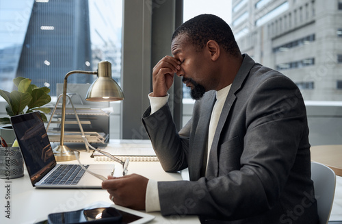 Businessman, stress and headache by laptop with tension for burnout, pressure and overworked. Office, migraine and frustrated accountant with pain for audit deadline, problem and exhausted at desk