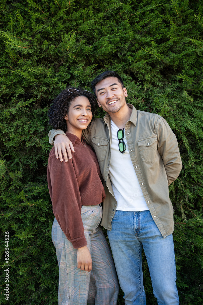 Multiethnic couple posing against greenery in Madrid, Spain Multiethnic couple posing against greenery in Madrid, Spain