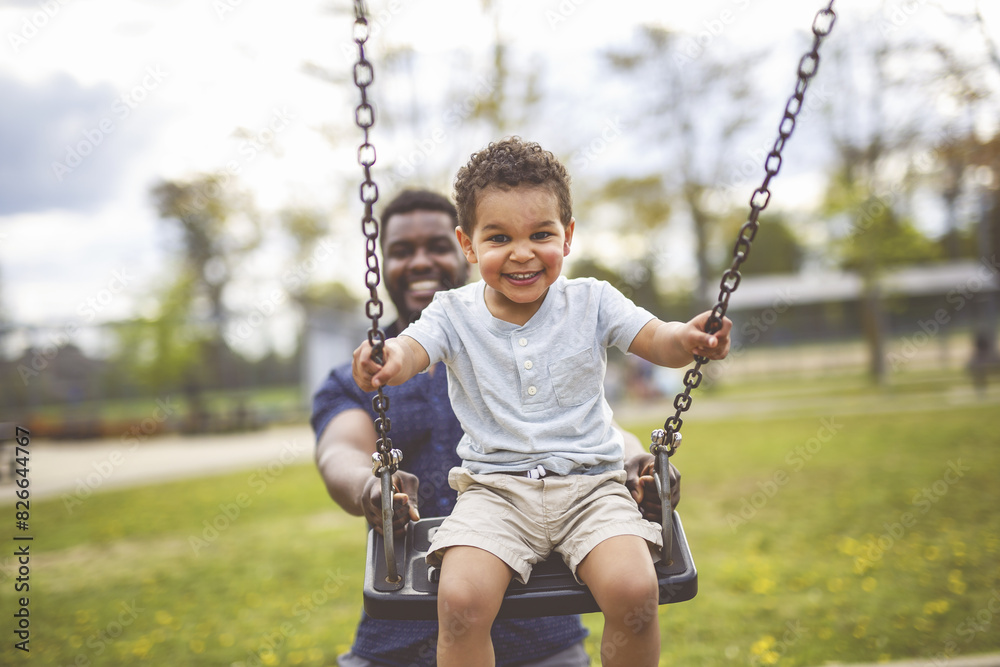 Playtime Moments. father With Her son Swinging Having Fun on the Playground Outside, Sharing Laughter and Joyful Bonding In Park Outdoors Playtime Moments. father With Her son Swinging Having Fun on the Playground Outside, Sharing Laughter and Joyful Bonding In Park Outdoors