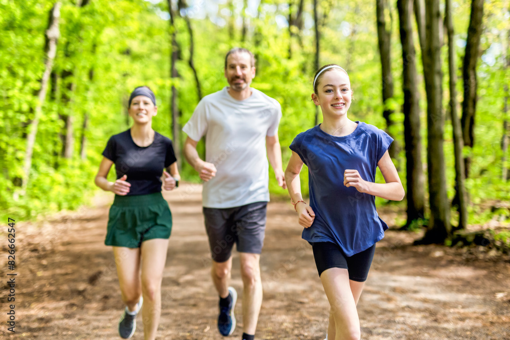 A Family exercising and jogging together at an outdoor park having great fun A Family exercising and jogging together at an outdoor park having great fun
