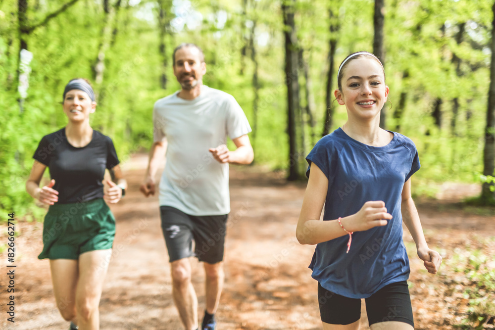 A Family exercising and jogging together at an outdoor park having great fun A Family exercising and jogging together at an outdoor park having great fun