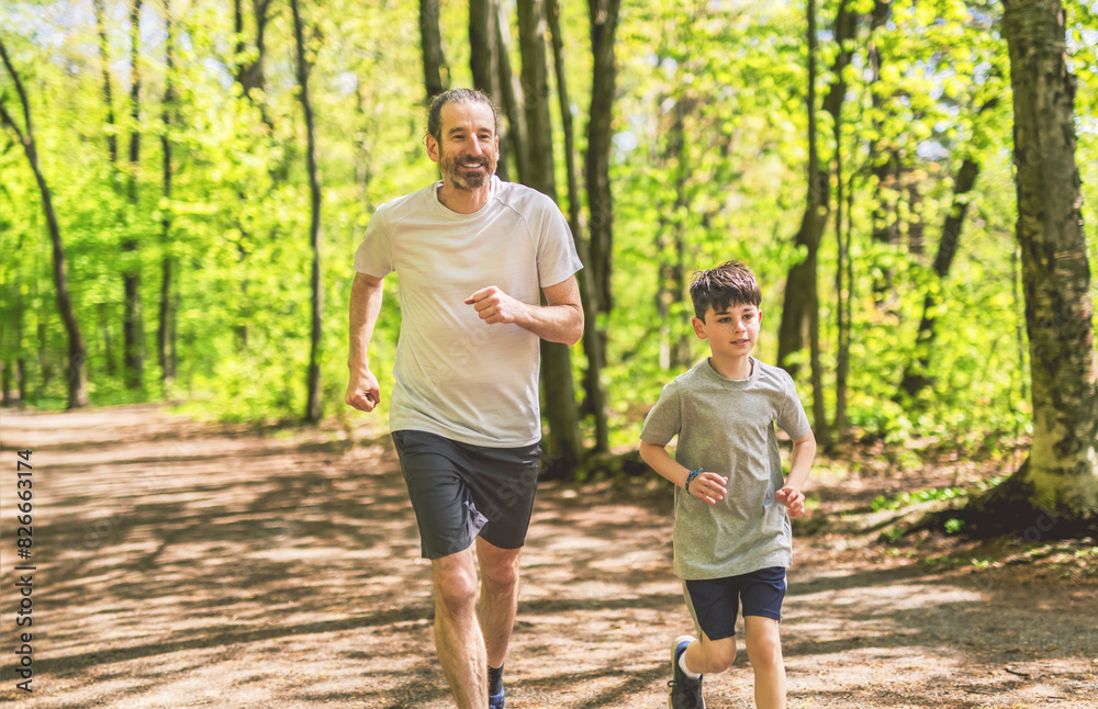 A father and son exercising and jogging together at an outdoor park having great fun A father and son exercising and jogging together at an outdoor park having great fun