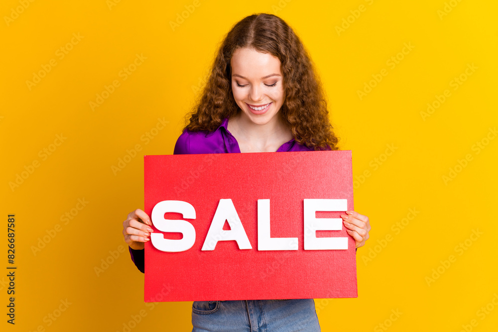 Photo portrait of lovely young lady look hold sale plate dressed stylish violet garment isolated on yellow color background Photo portrait of lovely young lady look hold sale plate dressed stylish violet garment isolated on yellow color background