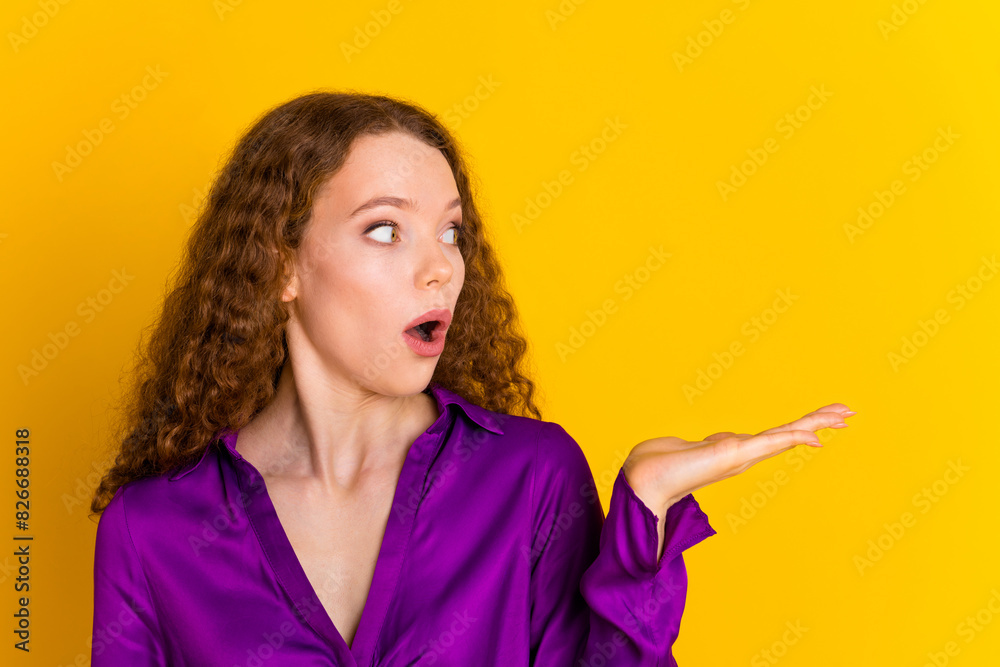 Photo portrait of pretty young girl scared amazed hold empty space wear trendy violet outfit isolated on yellow color background Photo portrait of pretty young girl scared amazed hold empty space wear trendy violet outfit isolated on yellow color background
