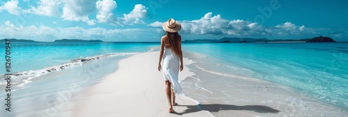 A serene scene of a woman in a white dress and straw hat strolling on a beautiful tropical beach, the tranquil seascape symbolizing an idyllic vacation getaway is a pictureperfect escape to paradise photo