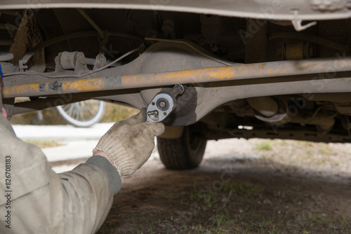 A mechanic is servicing the rear axle of a car.
