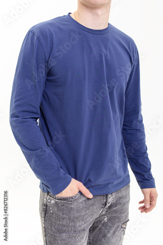 Young man in blue long sleeve shirt on white background. Sweatshirt and gray jeans