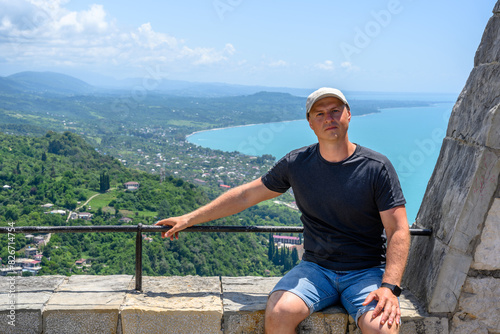 Man on the background of the Black sea and the city of New Athos in the Republic of Abkhazia photo