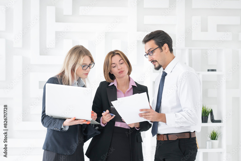 Successful business people standing in the bright office and smiling at camera Successful business people standing in the bright office and smiling at camera