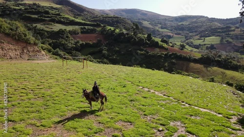 un joven y atractivo campesino montando un caballo caminando bajo la cálida luz del sol durante el día. Concepto de viaje de estilo de vida saludable, turismo experiencial.rural,quechua,estilo de vida photo