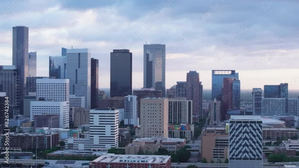 Aerial view of Houston's downtown skyline at dusk, showcasing modern skyscrapers and office buildings against a dramatic sky Aerial view of Houston's downtown skyline at dusk, showcasing modern skyscrapers and office buildings against a dramatic sky
