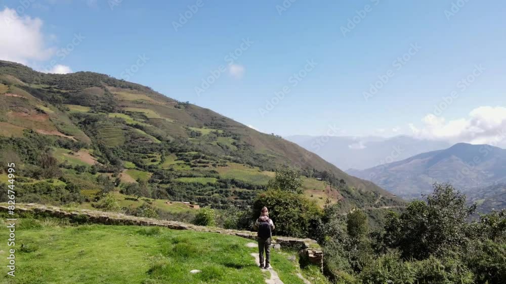 Hermosas montañas y hombre joven turista caminando con mochila en el camino en verano. Paisaje con turista en la cima de la montaña, bosque, colinas, cielo blancos con nubes, Viaje,quechua,sierra