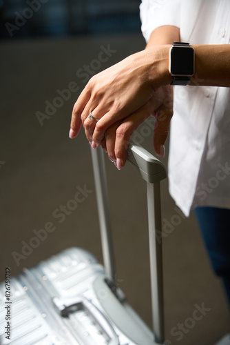 Cropped image of woman with suitcase in blurred hotel room at daytime © Svitlana